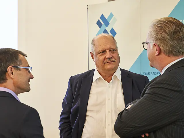 Drei Personen bei einer Unternhaltung