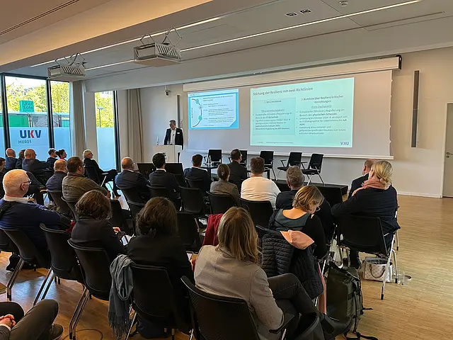 Mehrere Teilnehmer hören dem Referenten zu 