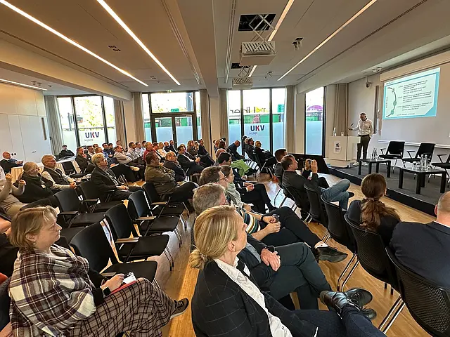 Mehrere Teilnehmer hören dem Referenten zu 